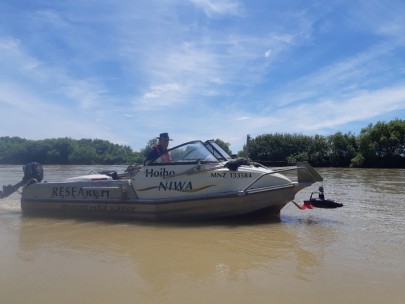 Figure 1.  The Sequoia LISST-SL2 deployed from a NIWA jet boat during a large flood event in the Ōreti River, Southland, February 2020.  The streamlined sensor (black instrument suspended from the boat crane) measures particle size distribution and provides suspended sediment samples at different depths through the water column. Andrew Wilsman, NIWA Dunedin, is at the jetboat helm. (Photo: Arman Haddadchi, NIWA Christchurch)  