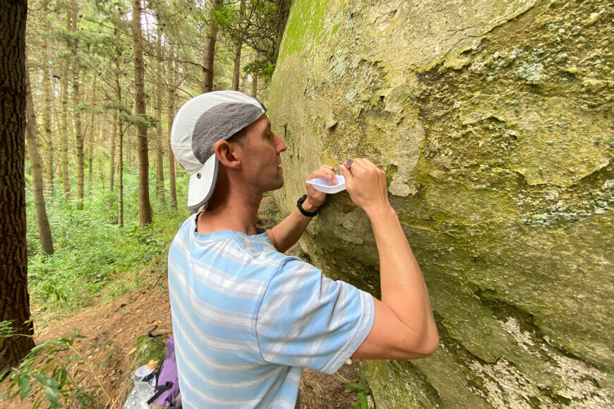 Dr Phil Novis collecting a sample at a rock art site. Image: John Hunt