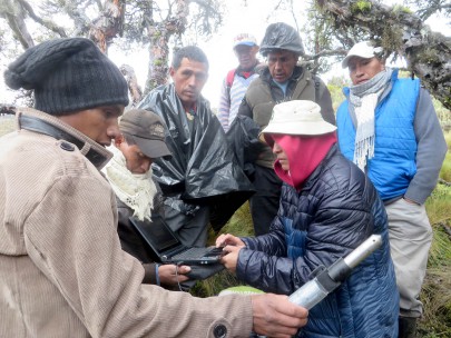 Marcia Chancusig (CESA) with Toacaso community members downloading river level data at a river monitoring site under Volcan Illinizas for planning a water supply scheme.