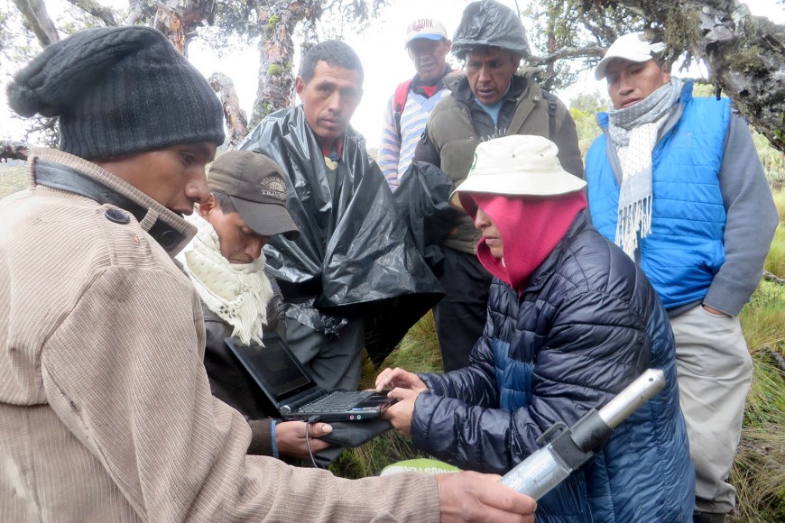 Marcia Chancusig (CESA) with Toacaso community members downloading river level data at a river monitoring site under Volcan Illinizas for planning a water supply scheme.  