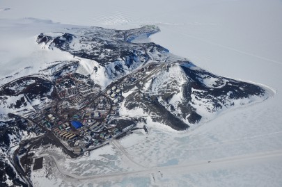 Aerial photograph of McMurdo Station (US, foreground) and Scott Base (New Zealand, green buildings at top).