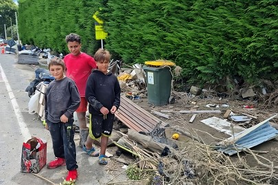 Young people helping move damaged property to the roadside ready for pickup by the Army in Omāhu.